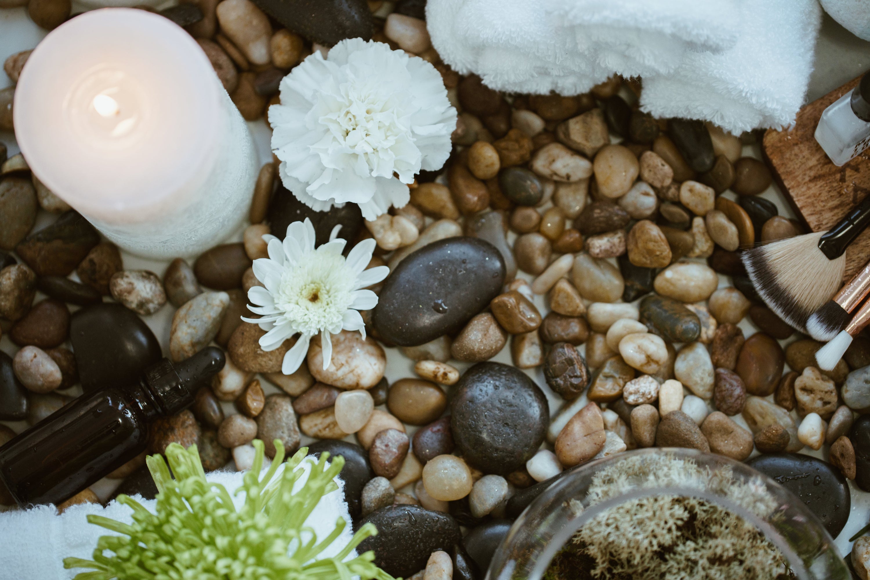 A relaxing view of spa items. Natural rocks, fresh flowers, and make-up brushes inspire beauty and melts stress away.