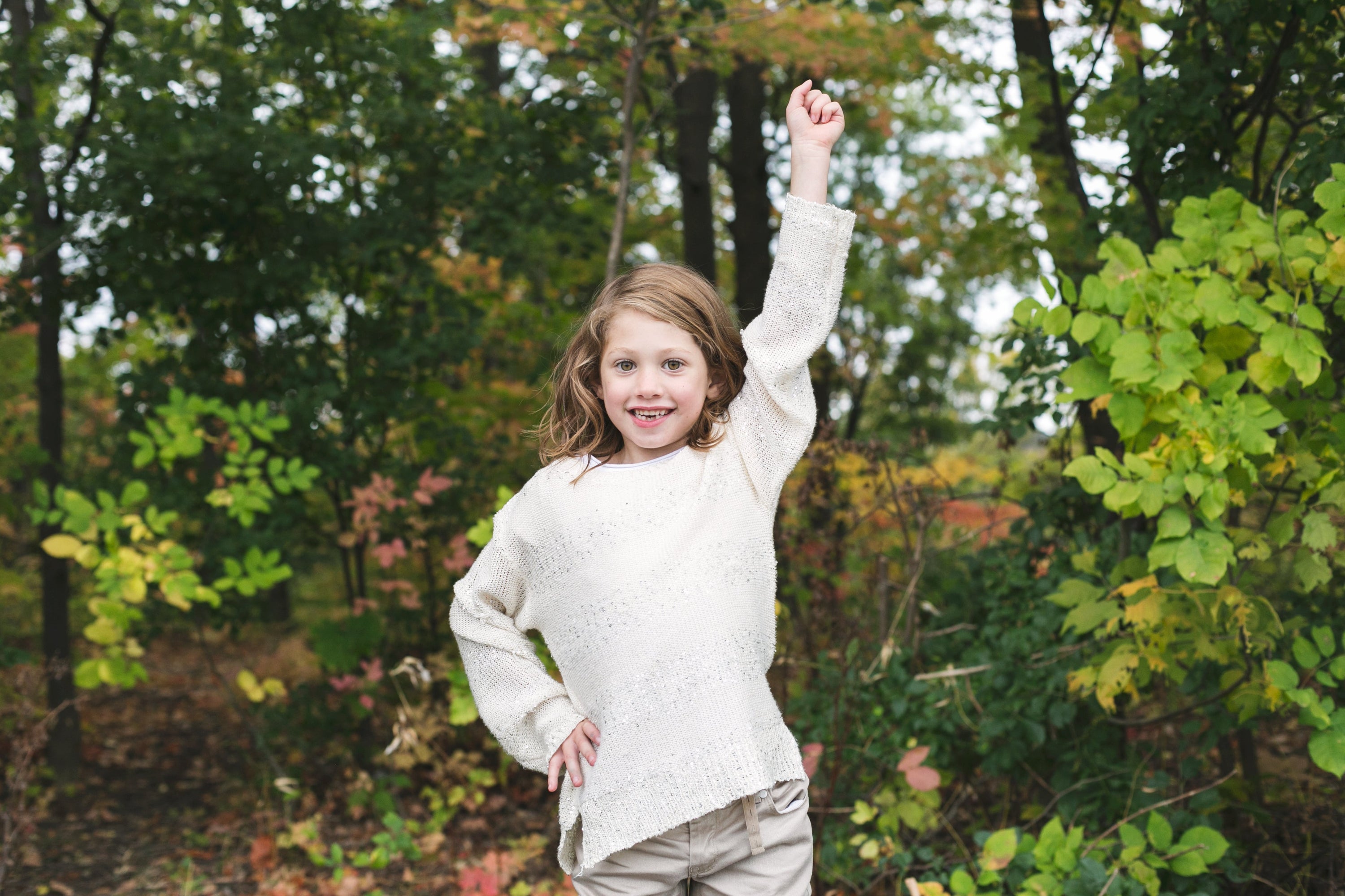 A girl striking a power pose. This kid has power. Just look at her! She will take over the world.