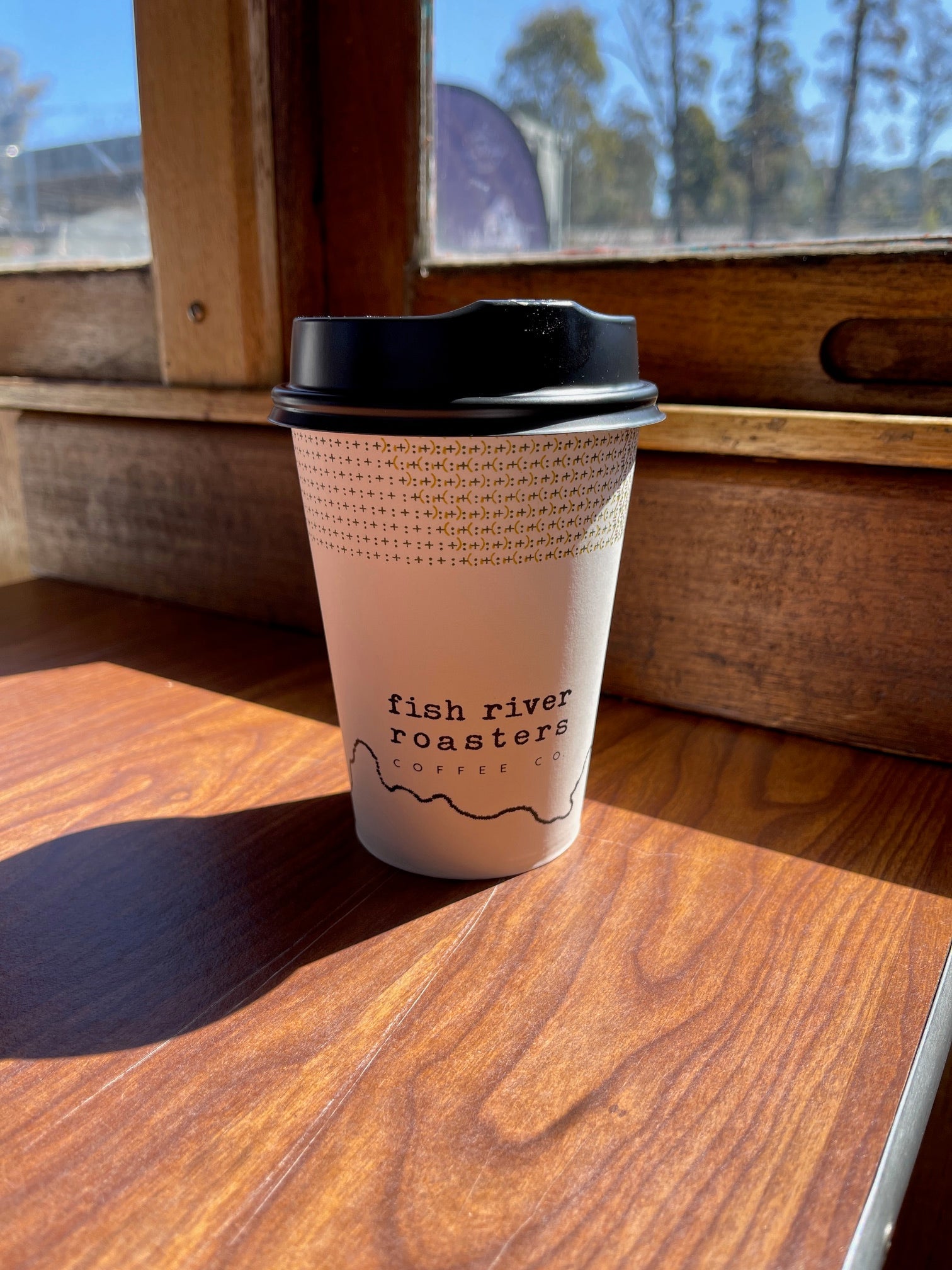 a coffee cup on the table of a train during the morning commute