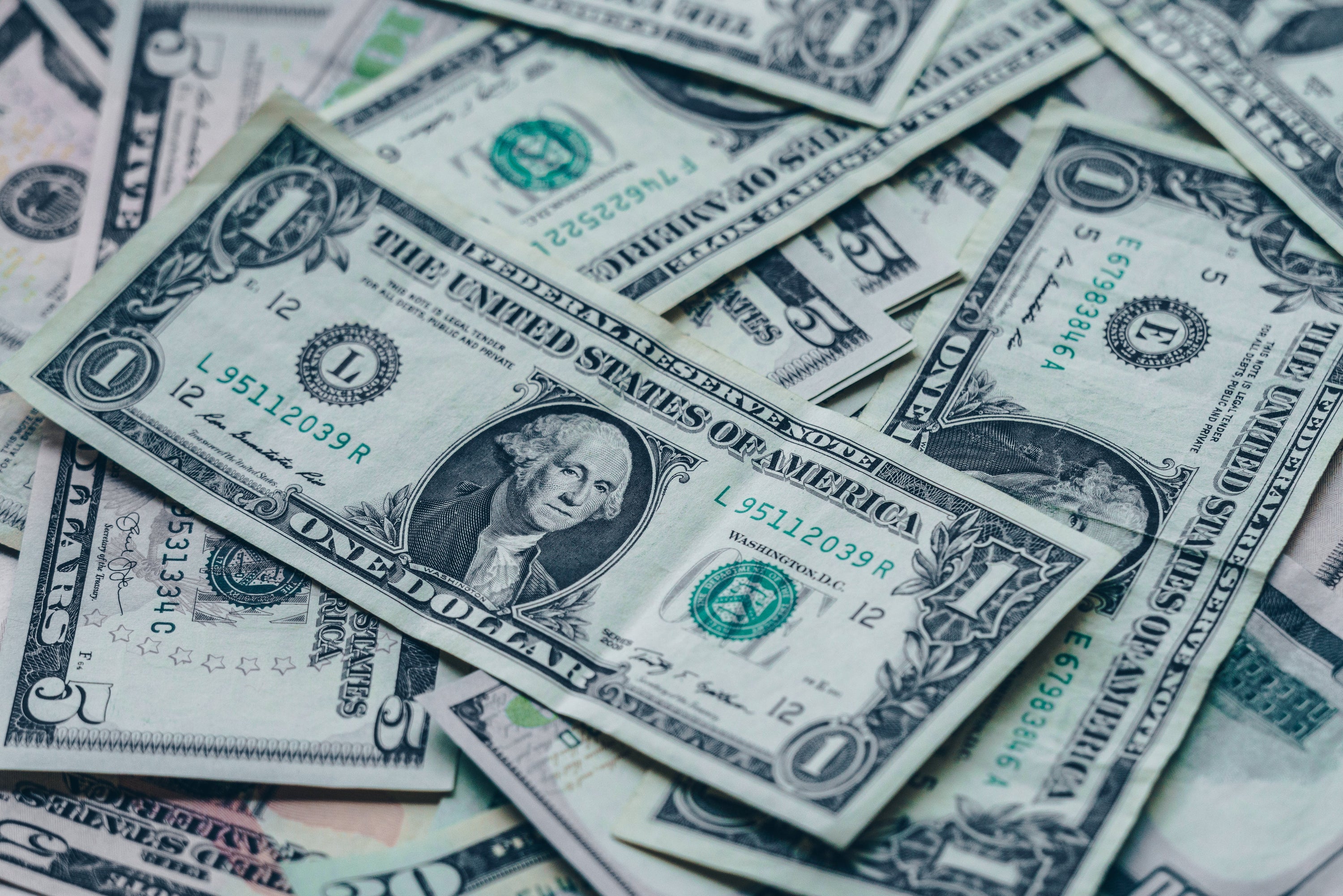 Closeup on one USD in a pile of paper bills.