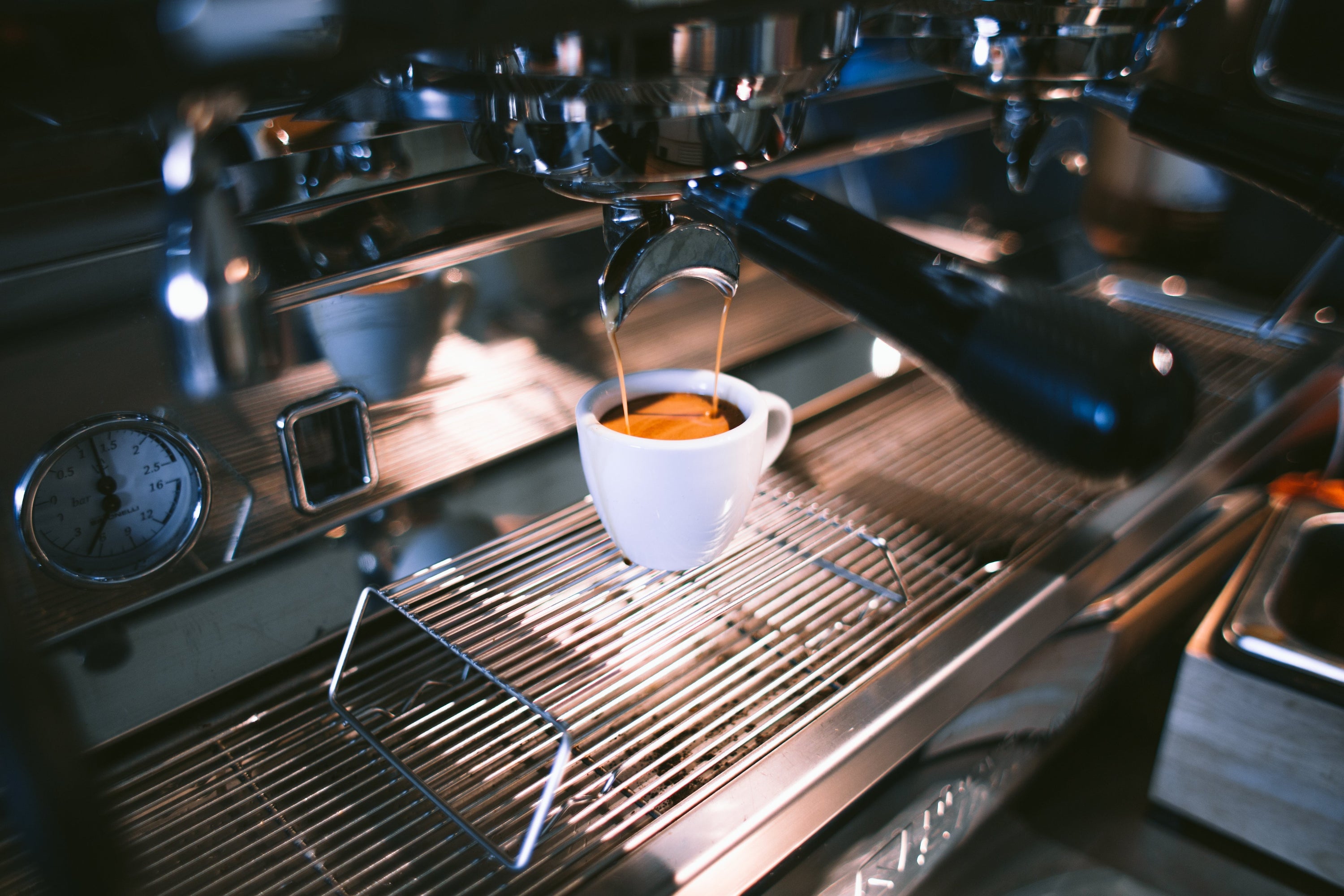 Espresso machine filling up espresso cup.