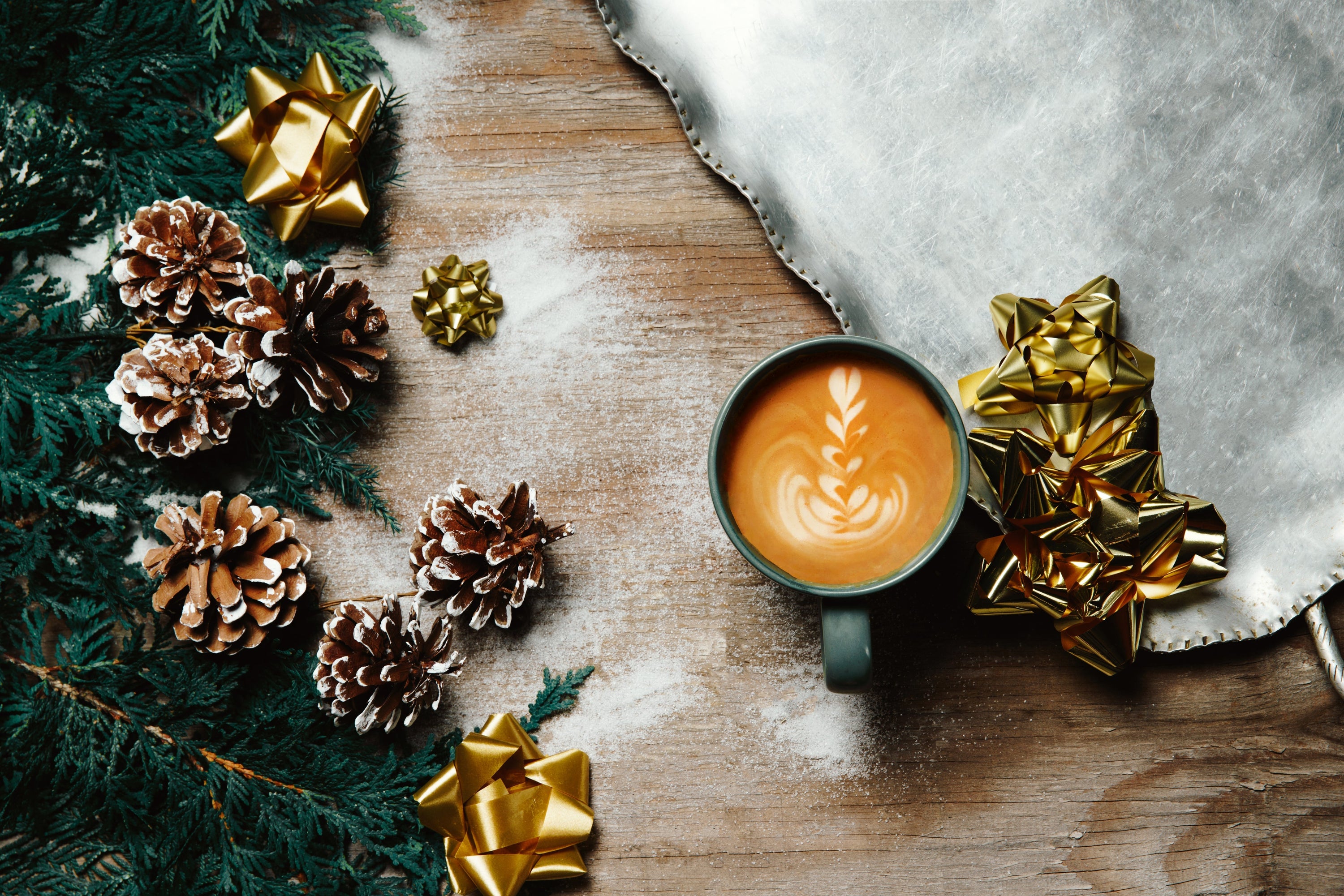 A hot drink with a design in the froth surrounded by Christmas decorations. Keeping warm while preparing for the holidays.