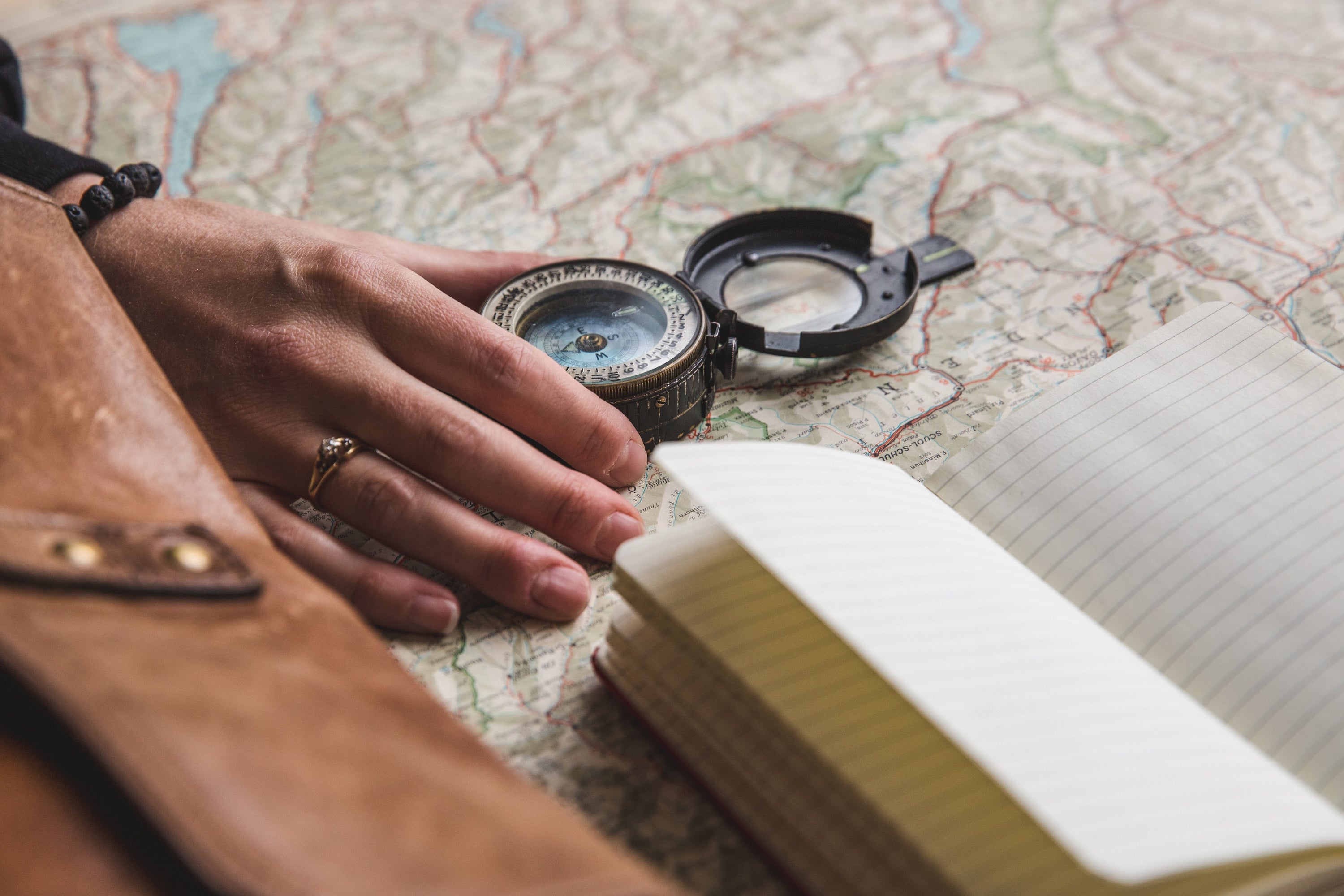 A young woman plans her journey with a compass and notebook at the ready.